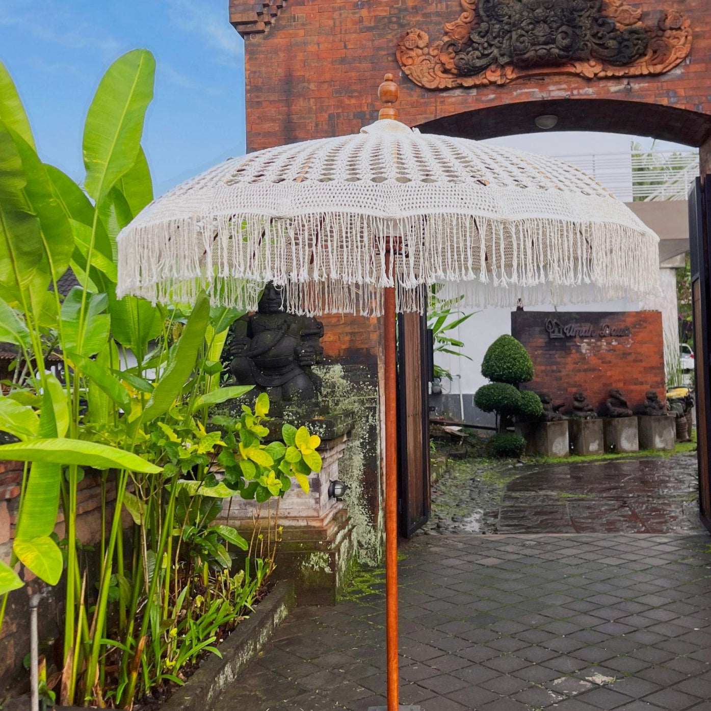 Decorative umbrella with intricate design in front of a traditional building entrance.