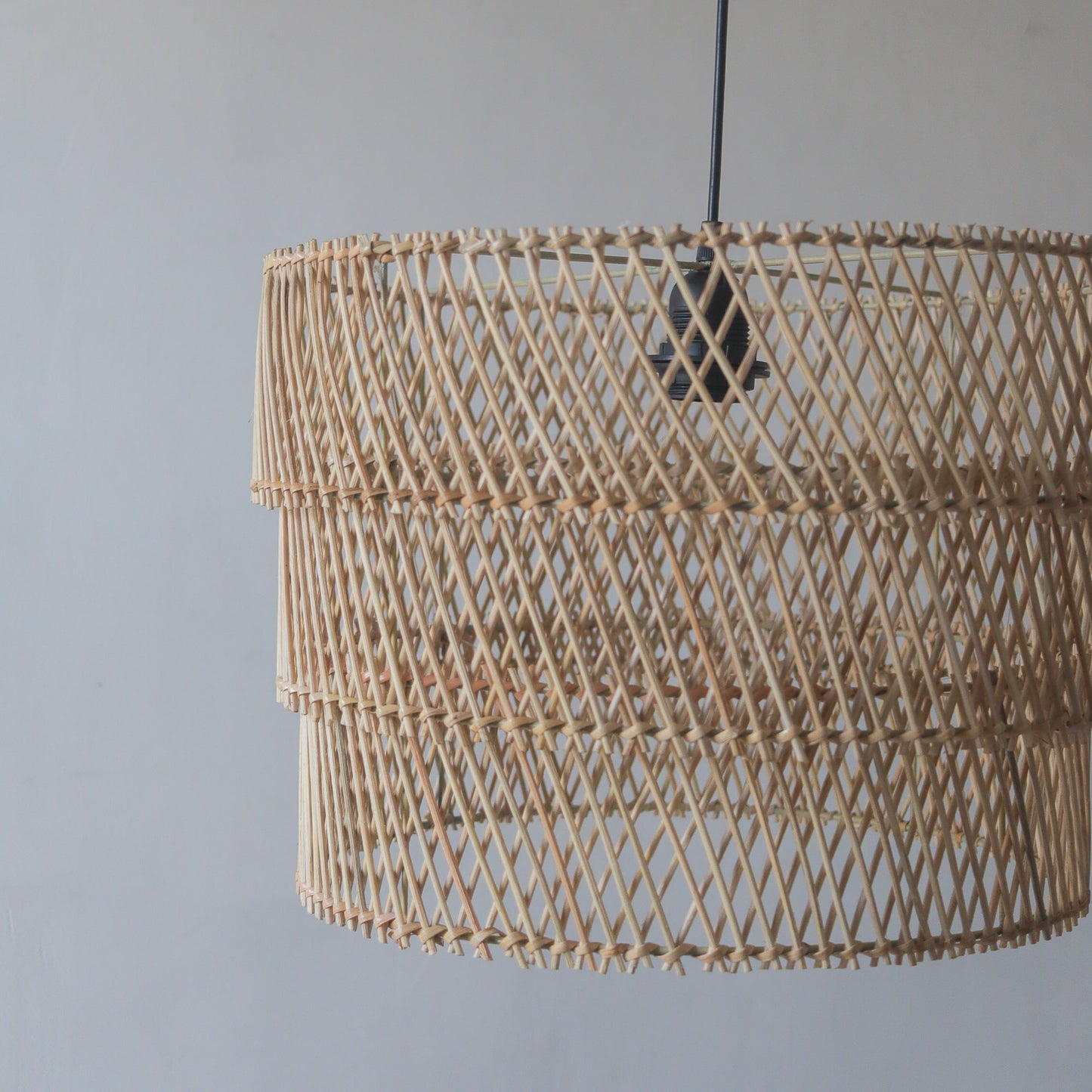 Handcrafted tiered rattan pendant light showcasing intricate weaving and unique design from Bali, Indonesia.