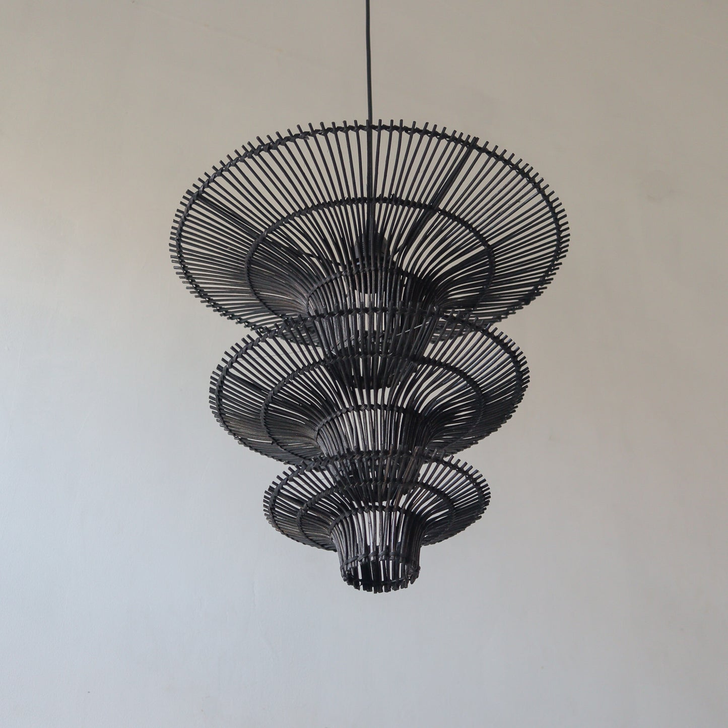 Handcrafted black rattan chandelier showcasing unique design and intricate motifs from Bali, Indonesia.