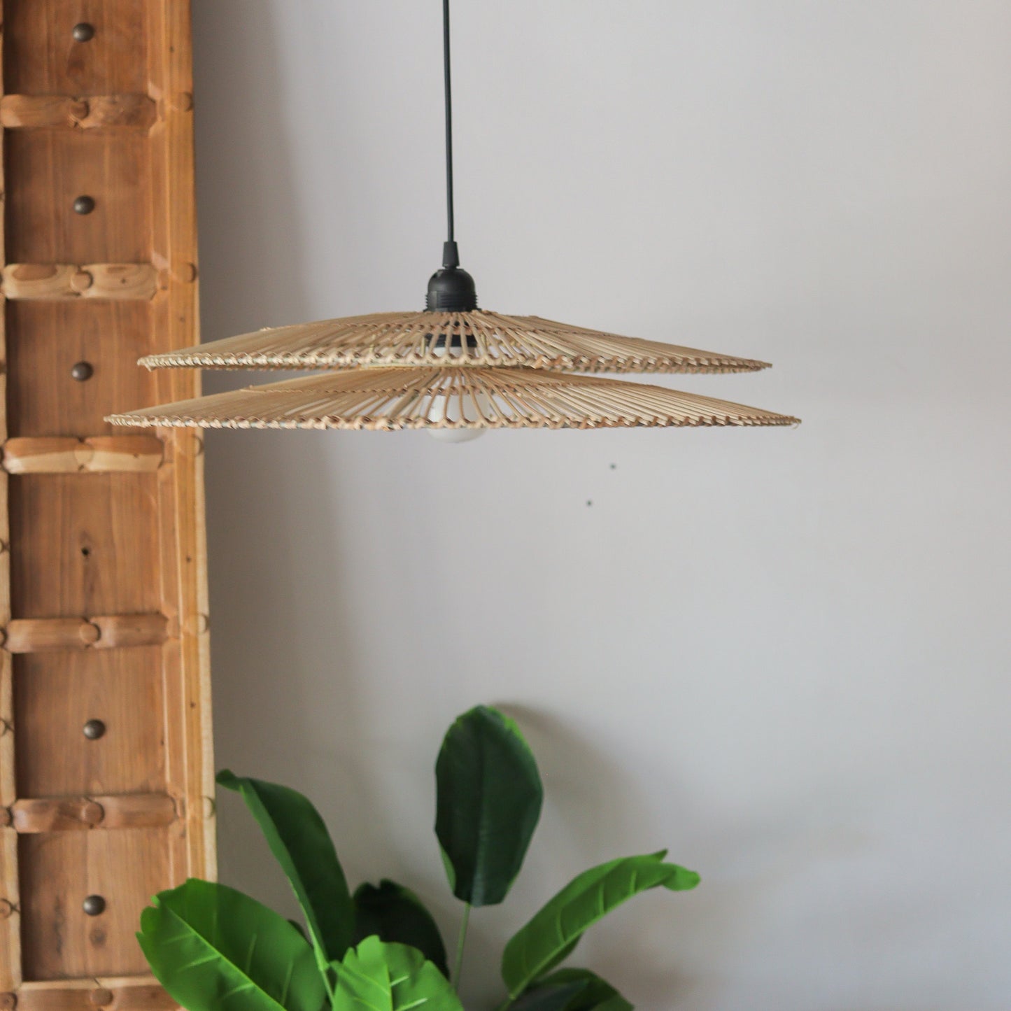 Handcrafted two-tiered rattan pendant light, showcasing unique Bali design and natural motifs.