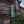 Balinese ceremonial umbrella with golden fabric and blue tassels by a brick temple wall