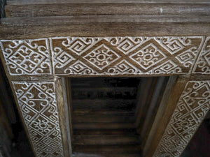 Hand-carved wooden door frame with intricate Balinese geometric patterns