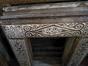 Hand-carved wooden door frame with intricate Balinese geometric and swirl patterns