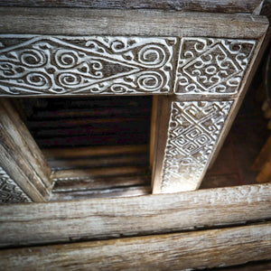 Hand-carved Balinese wooden furniture with intricate whitewashed patterns