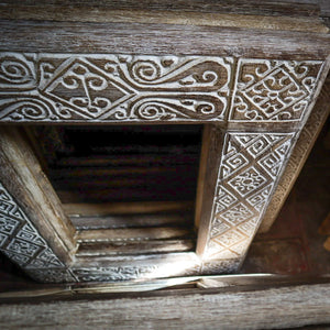 Hand-carved wooden door frames with intricate Balinese patterns and natural rustic finish