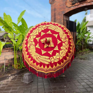 Balinese boho red and gold hand-painted parasol with intricate floral patterns outdoors