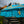 Balinese blue parasol with gold accents and decorative tosca fringe outdoors