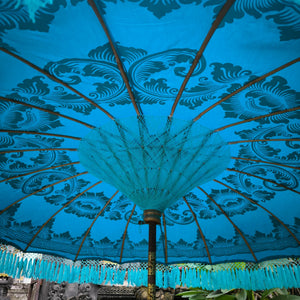 Balinese turquoise parasol umbrella with ornate hand-painted patterns and tassel fringe