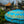 Balinese blue and gold decorative umbrella with tassels near traditional temple garden