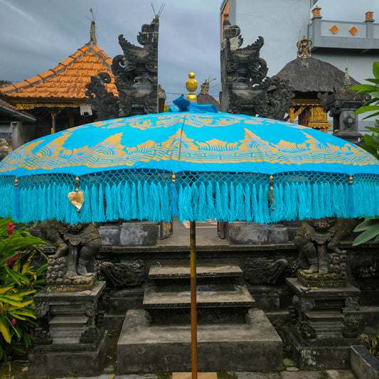 Blue decorative umbrella with gold accents in front of a temple structure.