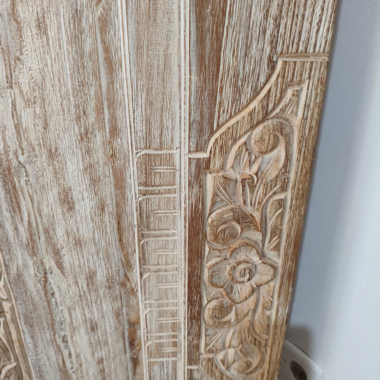 Wooden panel with intricate carvings on a white background