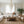 Modern living room with a white sectional sofa, wooden coffee table, and wicker chairs.