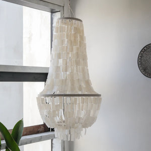 Elegant hanging capiz shell chandelier in a bright modern room with natural light.