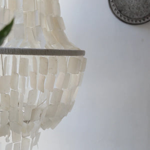Handmade capiz shell chandelier with rectangular white shells, coastal wall decor background