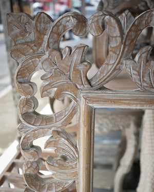 Hand-carved wooden mirror frame with intricate floral Balinese design.