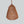Handwoven copper mesh chandelier with organic, tiered design on a plain background