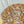 Hand-carved wood wall art with intricate leaf and branch design on a light fabric background