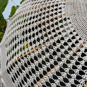 Hand-knitted macrame with intricate geometric pattern, outdoor decor with natural elements