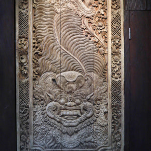 Hand-carved Balinese wooden wall panel with intricate floral and mythical face design
