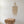 Boho seashell chandelier and hand-carved wooden nightstand in minimalist room