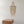 Handmade seashell chandelier ceiling light above carved wooden nightstand in minimalist room