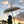 Balinese stone statue under decorative parasol at sunset with tropical sky