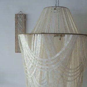 Handmade Balinese seashell chandelier with layered white capiz shells, boho wall art