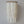 Handmade white seashell chandelier with cascading strands against a plain wall
