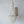 Handmade seashell chandelier with intricate beading, hanging on a white wall.