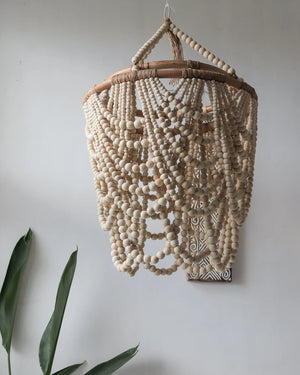 Handmade wooden bead chandelier with natural finish hanging in a minimalist interior