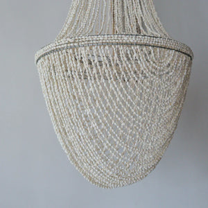 Handmade seashell chandelier with intricate beadwork against a plain white background