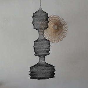Handwoven Balinese pendant light and decorative rattan wall art on a neutral wall.