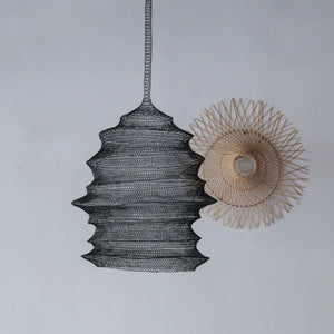 Handcrafted black wire pendant lamp and natural rattan lampshade on white wall