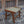 Handcrafted wooden and rattan stool with woven seat on stone patio near rustic door