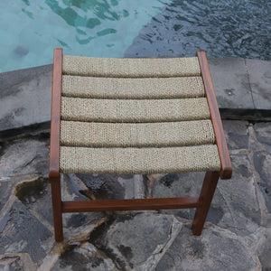 Eco-friendly woven rope stool with wooden frame by a stone poolside