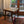 Handcrafted wooden stool with woven seat in a cozy room, near window and patterned rug.