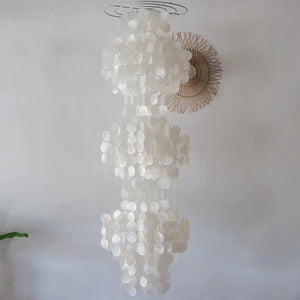Decorative chandelier made of circular white elements on a plain background