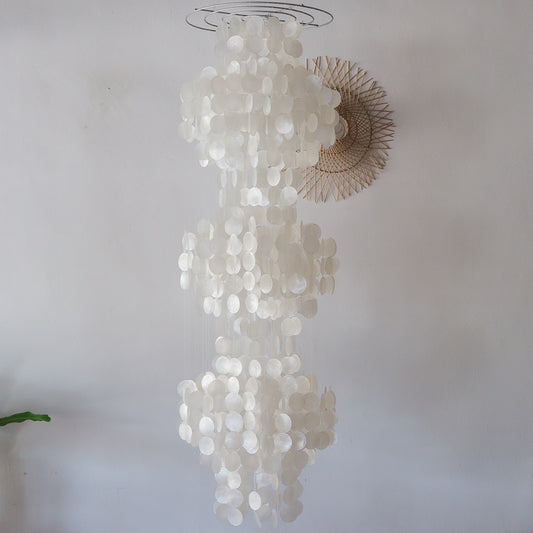 Decorative chandelier made of circular white elements on a plain background