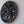 Hand-carved black wood wall art with intricate tree of life design on a white wall