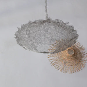 Handcrafted woven metal pendant light with scalloped edges against a white background