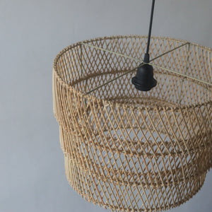 Handcrafted tiered rattan pendant light from Bali, showcasing unique motifs and natural colors.