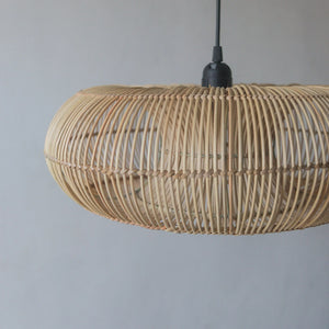 Handcrafted rattan pendant light in donut design from Bali, showcasing unique artistry and natural variations.