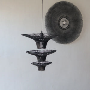 Handcrafted black rattan chandelier hanging, featuring unique tiered design and intricate motifs, inspired by Balinese craftsmanship.