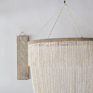 Handmade seashell chandelier with natural hanging beads and carved wood wall art