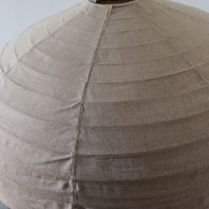 Close-up of hand-stitched natural linen lampshade with textured fabric detail
