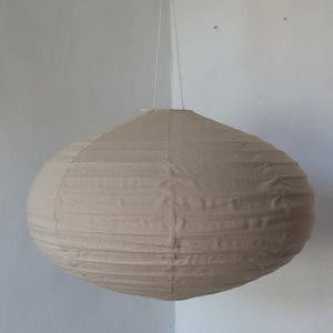 Round beige fabric pendant lamp with minimalist design hanging indoors