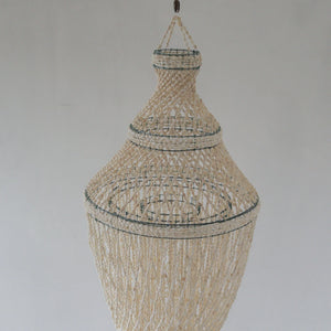 Handmade Balinese seashell chandelier with intricate woven design against a plain background
