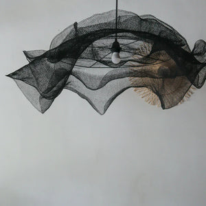 Modern black mesh pendant light with sculptural design hanging from ceiling