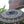 Balinese decorative umbrella with gold patterns, outdoor temple gate and greenery