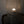 Handmade woven mesh lampshade with glowing bulb, rattan chair in background